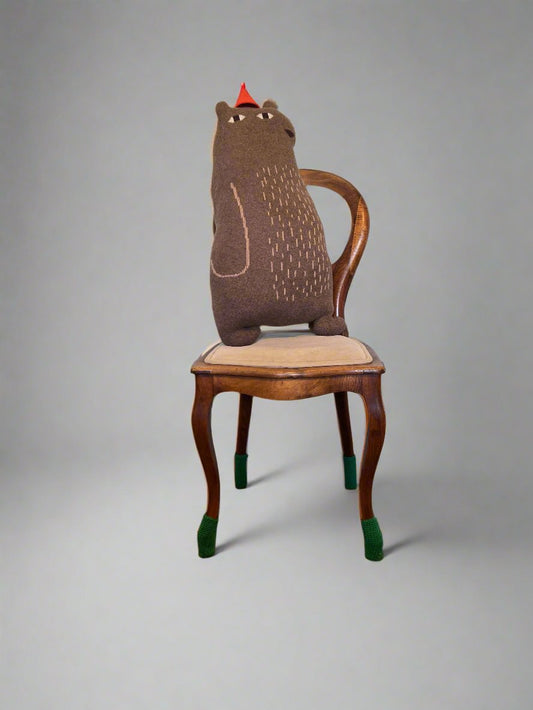 Bear stuffed animal designed by Donna Wilson, inspired by Jon Klassen, featuring a cozy, minimalist style. Knitted with lambswool.