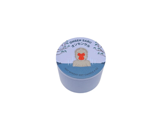 Onsen Saru Candle in a tin, hand-poured soy candle scented with Japanese matsu pine, cedarwood, snow, and Himalayan pink salt.