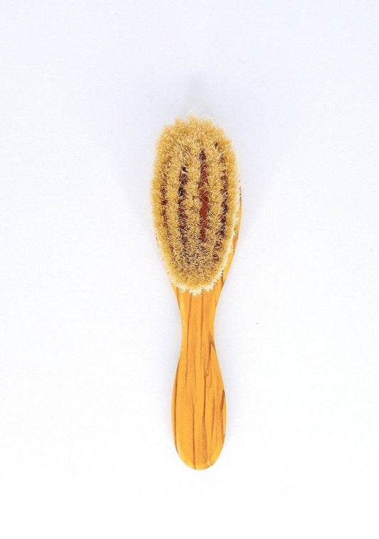 Redecker baby brush with soft goat hair bristles and a wooden handle.